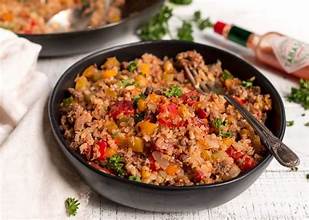 Bowl of vegan Cajun dirty rice with vegetables and herbs