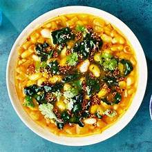 Bowl of hearty vegan mustard greens with white beans in savory broth